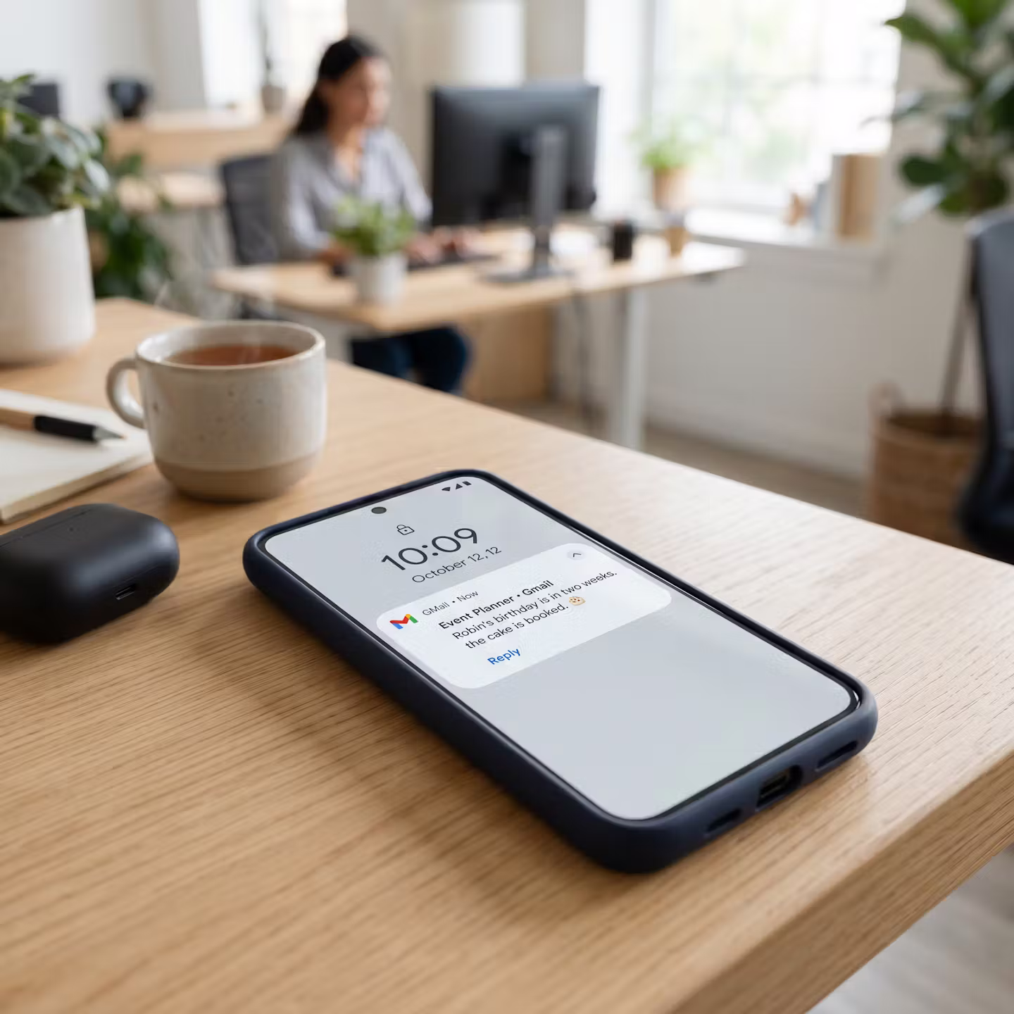 Mobil på skrivbord som visar mejl med bekräftelse att födelsedagstårta är bokad två veckor innan